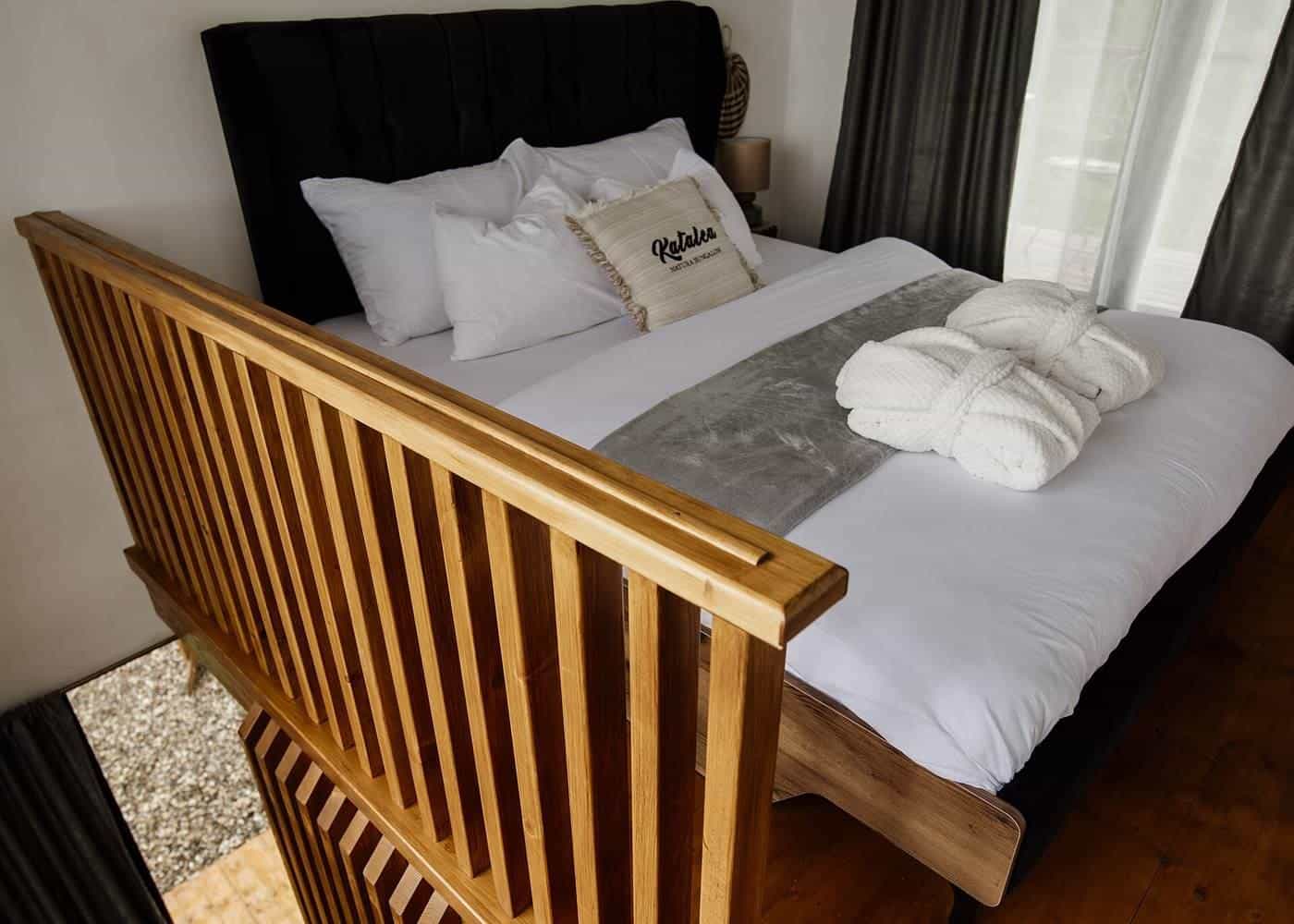 A neatly made bed with white pillows and a throw blanket in a calm bedroom