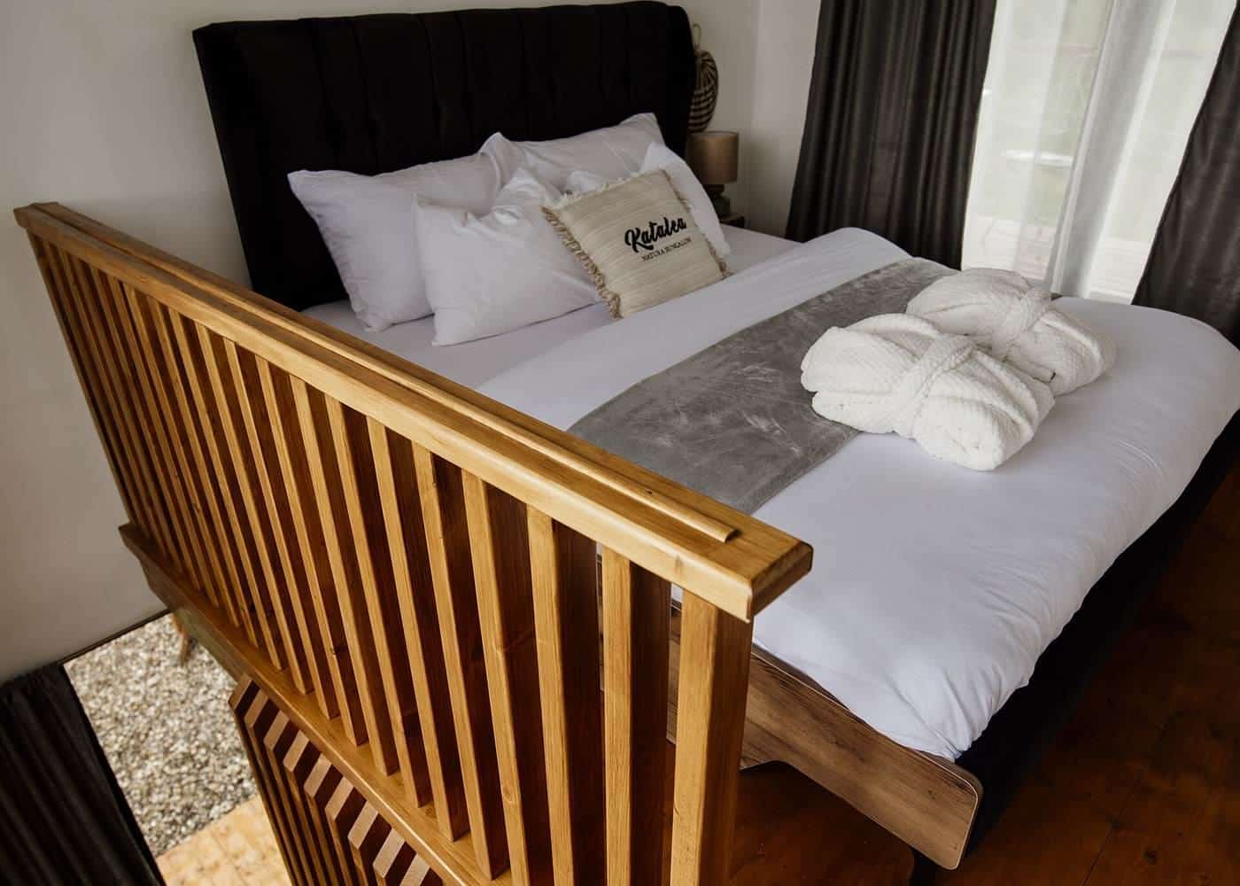 A neatly made bed with white pillows and a throw blanket in a calm bedroom